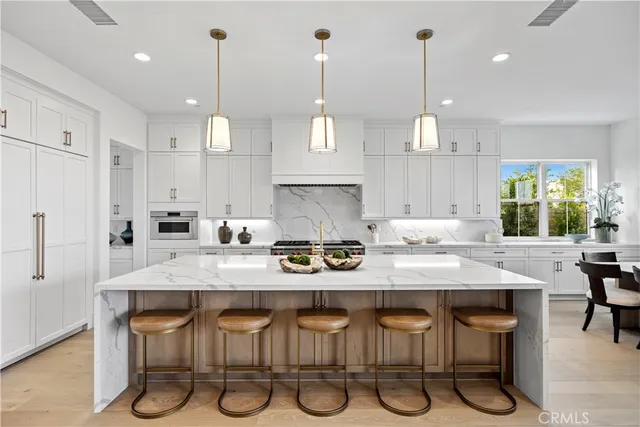 a kitchen with stainless steel appliances a stove a sink and white cabinets