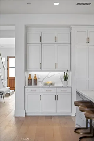 a large kitchen with kitchen island a stove a table a sink a refrigerator and chairs