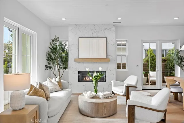 a living room with furniture a fireplace and a large window
