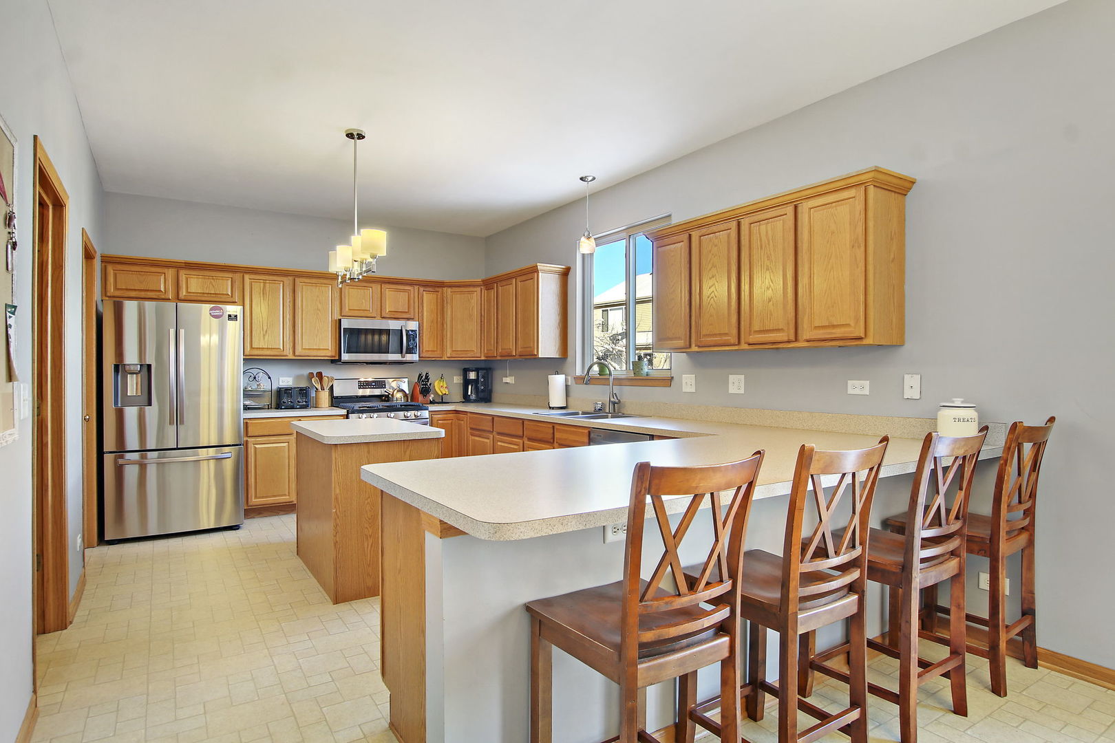 25663 Brooks Farm Road Round Lake, IL 60073 - Photo 4 of 33 a kitchen with a table chairs refrigerator and microwave