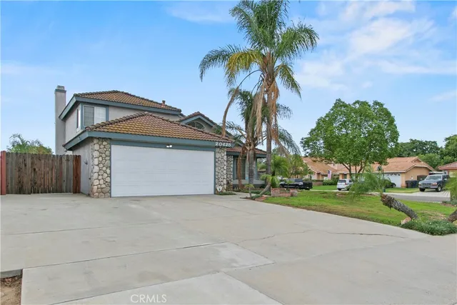 a front view of a house with a garden and trees