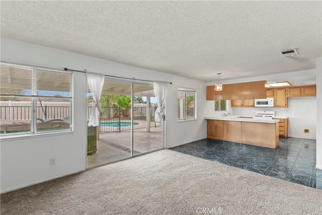 a large white kitchen with a large window and kitchen view