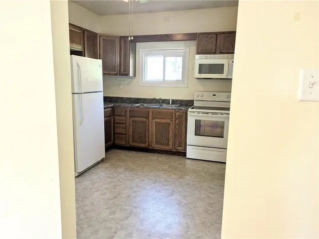 a kitchen with stainless steel appliances granite countertop a refrigerator a stove a sink and dishwasher