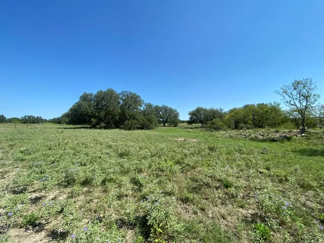 a view of a green field with wooden fence