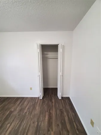 an empty room with wooden floor and ceiling fan