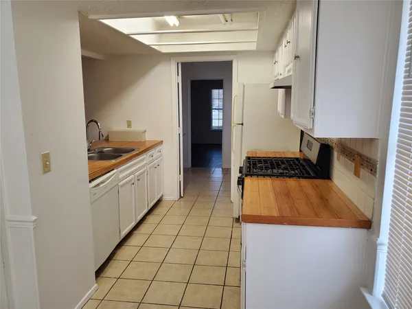 a kitchen with granite countertop a refrigerator and a stove top oven