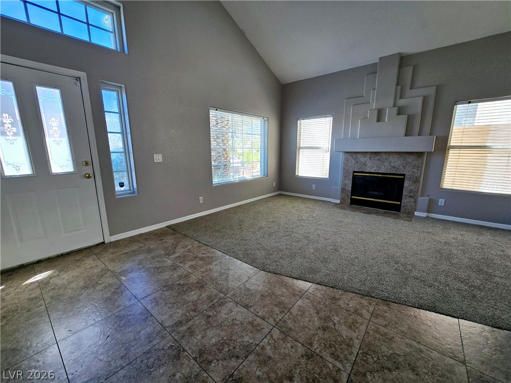 3759 Funston Way Las Vegas, NV 89129 - Photo 25 of 31 A spacious living room features vaulted ceilings, tile flooring at the entry, and a distinctive fireplace.