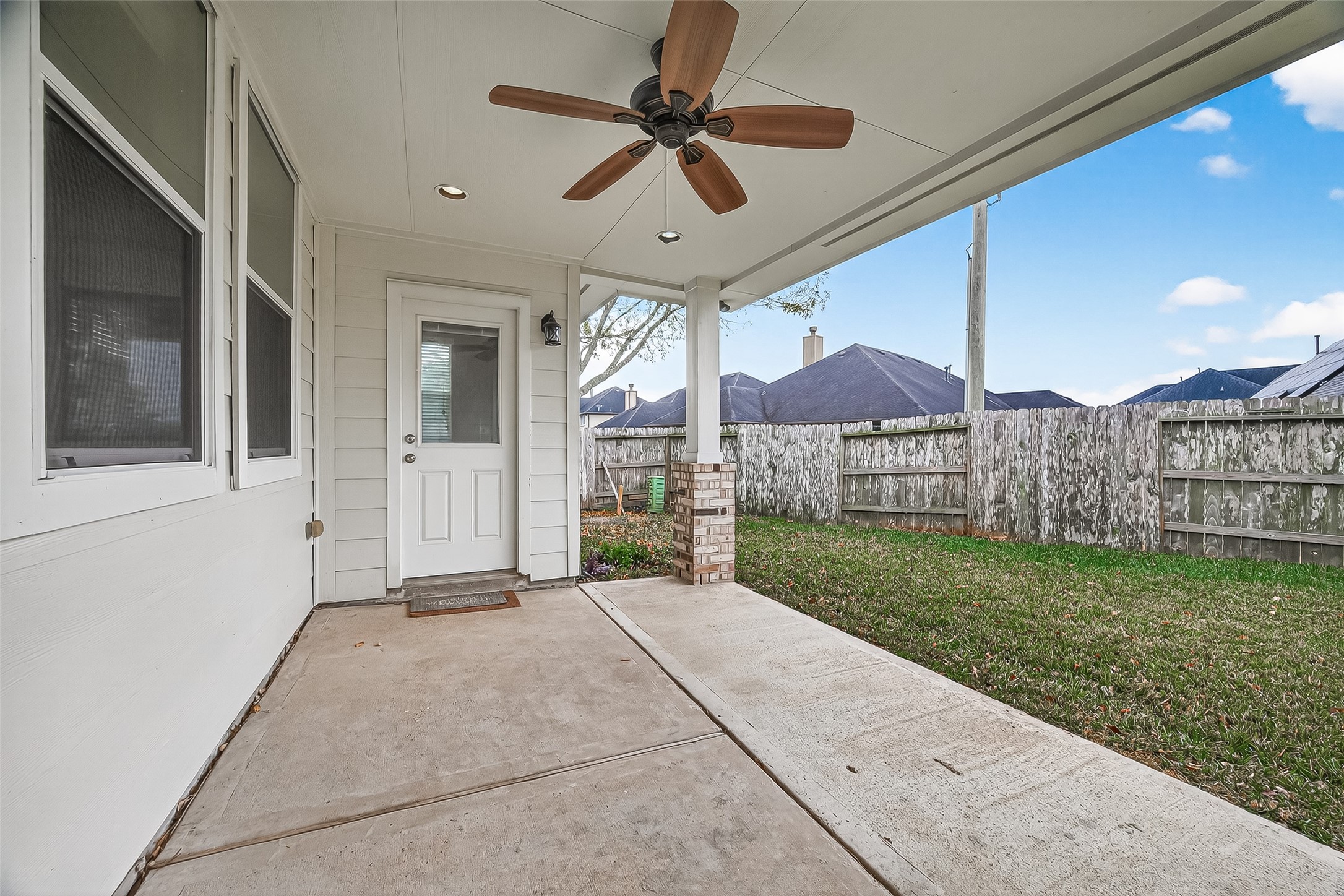 9110 Cavalier Lane Rosenberg, TX 77469 - Photo 27 of 30 The covered patio with a ceiling fan, provides a comfortable outdoor space. It opens to a fenced backyard, offering privacy and a grassy area for relaxation or play.