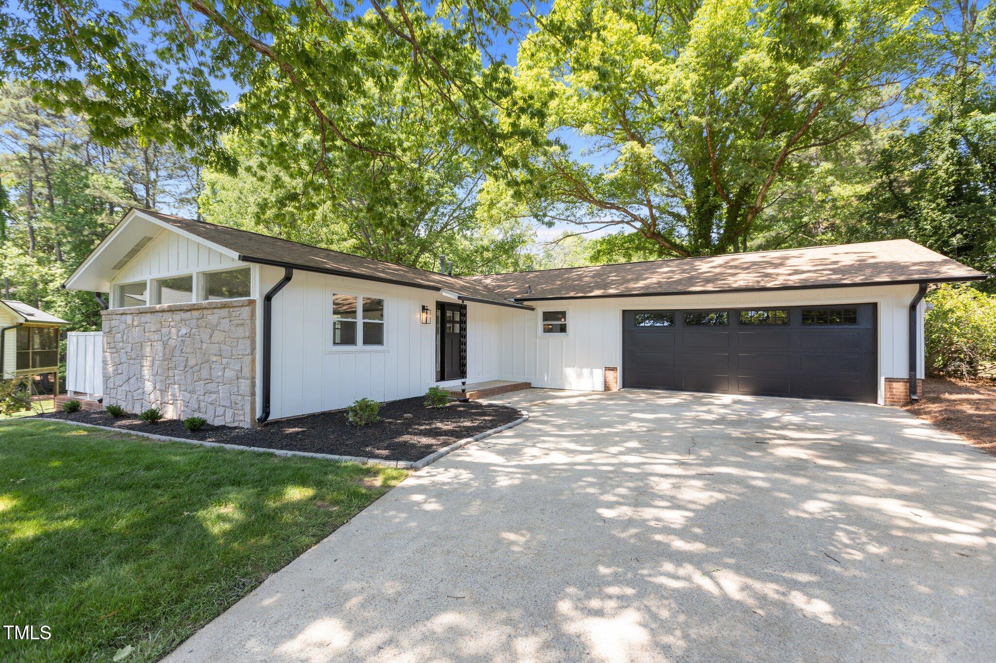 a view of a house with a yard and large tree