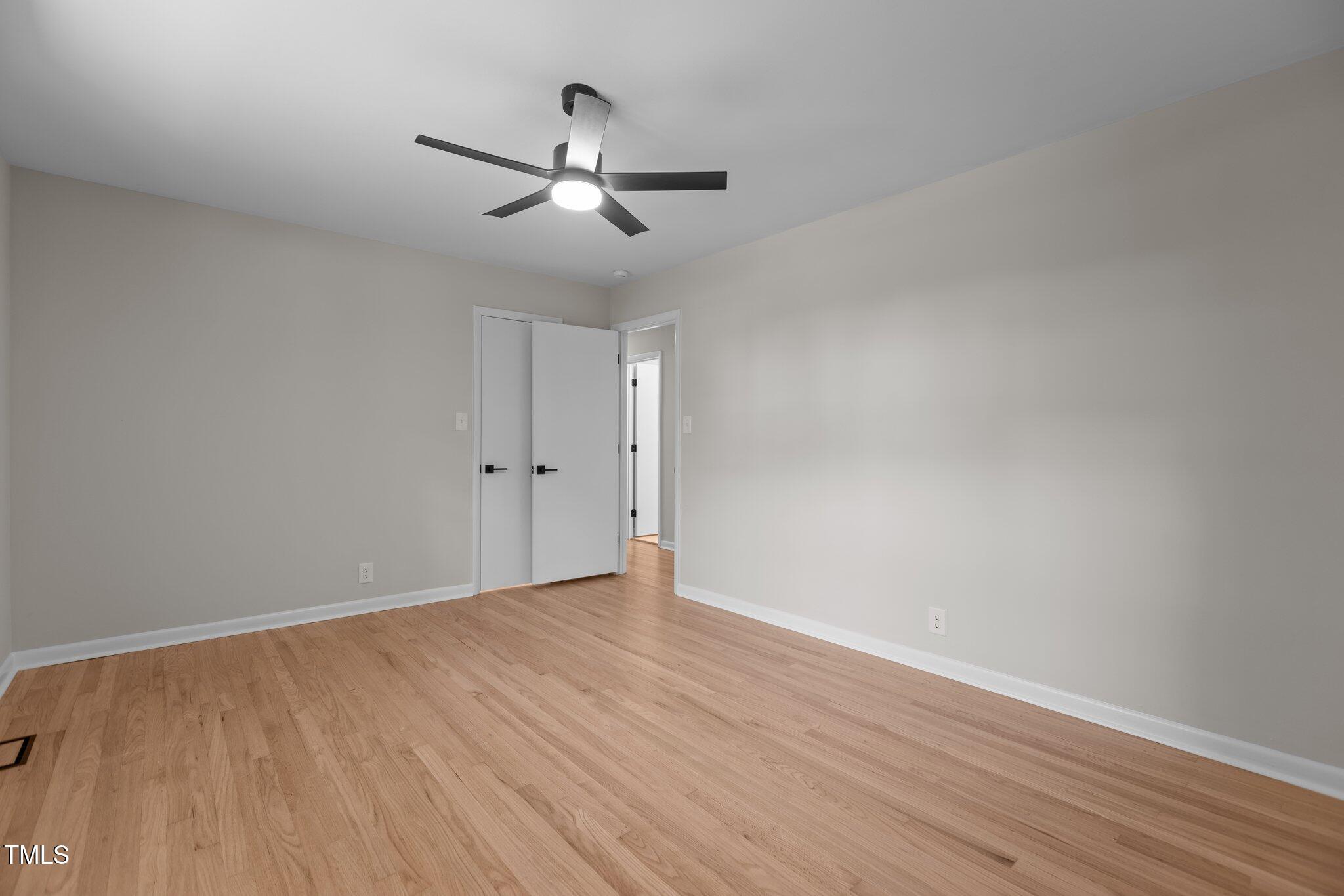 2505 Catalina Court Raleigh, NC 27607 - Photo 17 of 25 an empty room with wooden floor chandelier fan and windows