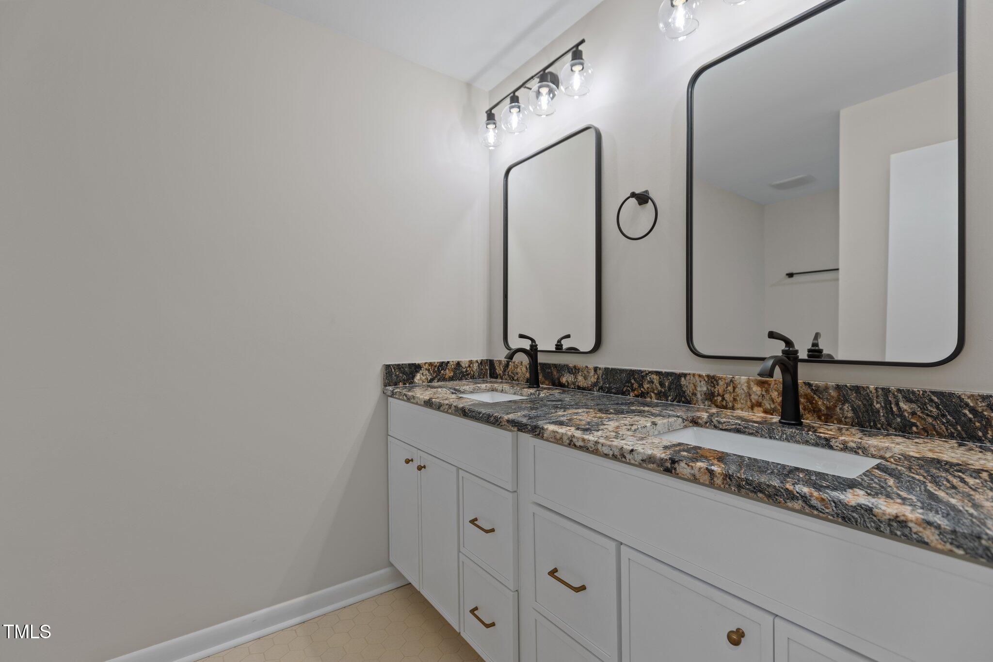2505 Catalina Court Raleigh, NC 27607 - Photo 18 of 25 a bathroom with a double vanity sink and a mirror