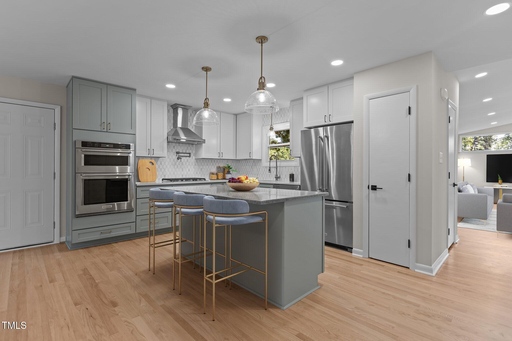 2505 Catalina Court Raleigh, NC 27607 - Photo 6 of 25 a kitchen with kitchen island stainless steel appliances a stove a sink and a refrigerator