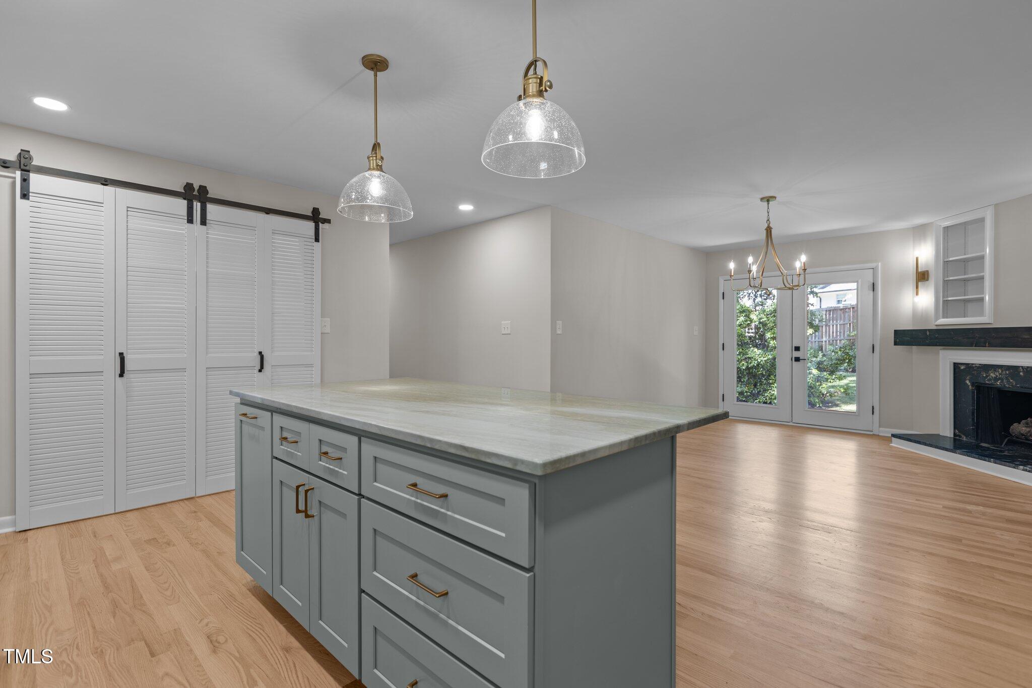 2505 Catalina Court Raleigh, NC 27607 - Photo 7 of 25 a kitchen with kitchen island a chandelier wooden floor and a chandelier