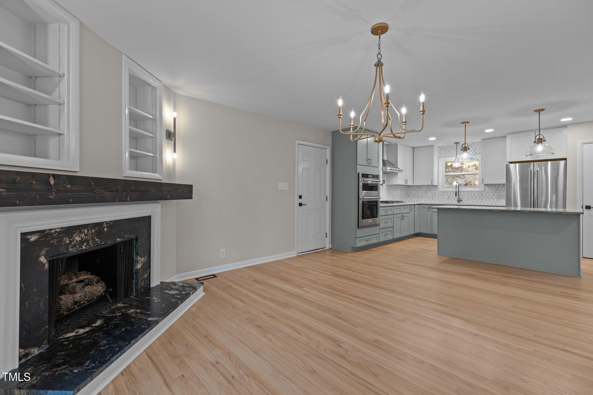 2505 Catalina Court Raleigh, NC 27607 - Photo 8 of 25 a open kitchen view with fireplace a center island and stainless steel appliances