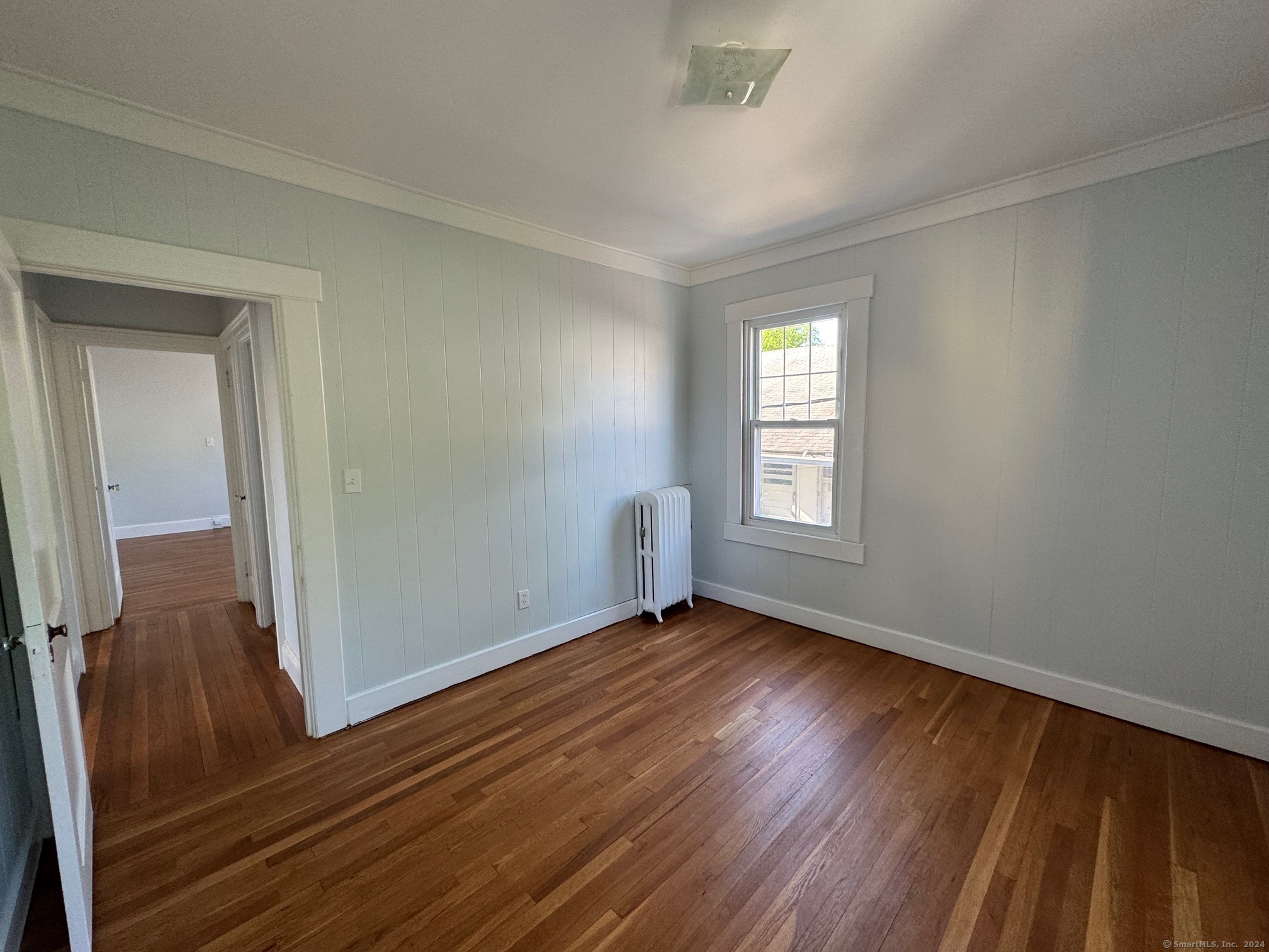 1253 Forest Road, Unit 2 New Haven, CT 06515 - Photo 27 of 30 a view of an empty room with wooden floor and a window