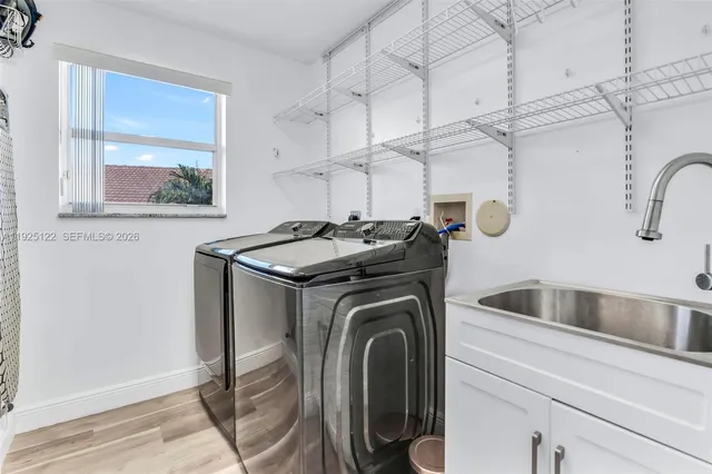 a utility room with sink dryer and washer