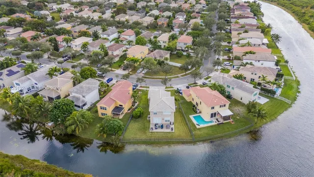 an aerial view of residential houses with outdoor space and lakeside
