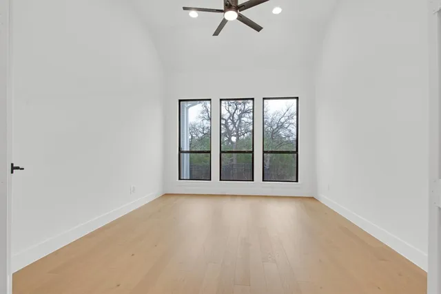 a living room with furniture hard wood floor and floor to ceiling window