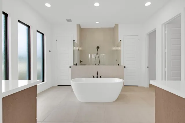 a spacious bathroom with a double vanity sink a mirror and a bathtub