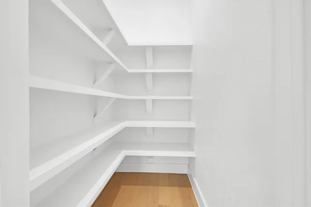 a large white kitchen with a large counter top appliances and cabinets