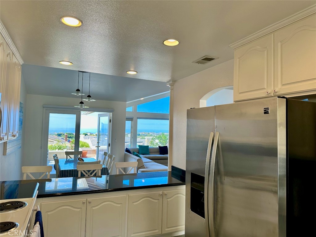 33635 Capstan Drive Dana Point, CA 92629 - Photo 11 of 33 a kitchen with stainless steel appliances granite countertop a refrigerator a oven and white cabinets with wooden floors
