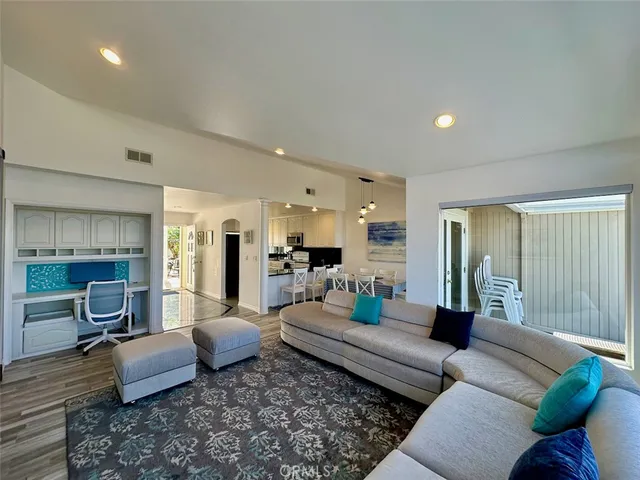 a living room with furniture a fireplace and a open kitchen view