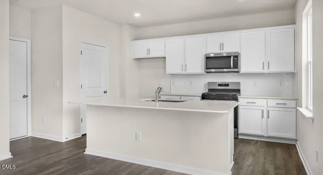 a kitchen with stainless steel appliances a sink a stove a microwave and cabinets