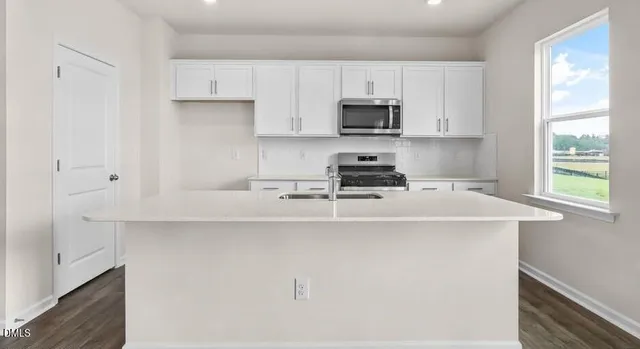 a kitchen with stainless steel appliances a white cabinets stove and a refrigerator