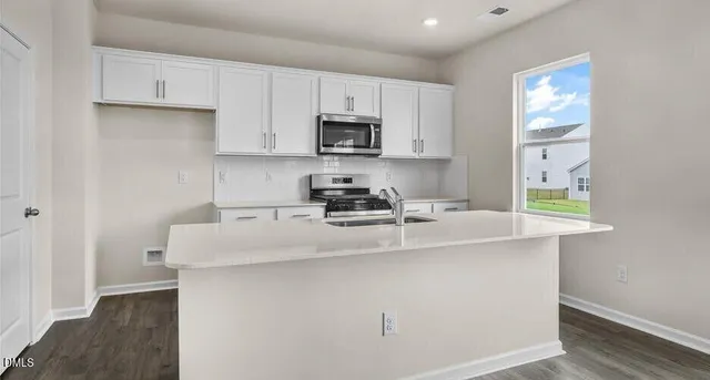 a kitchen with stainless steel appliances granite countertop a sink a stove and a refrigerator