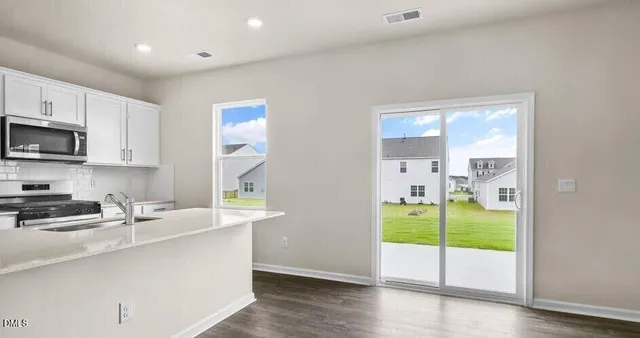 a kitchen that has a lot of fruit cabinets and a wooden floor