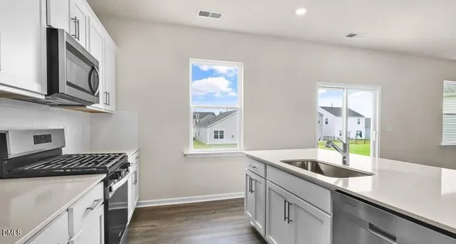 a kitchen with stainless steel appliances granite countertop a sink and a stove