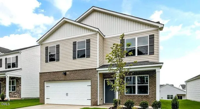 a view of a house with a yard and potted plants