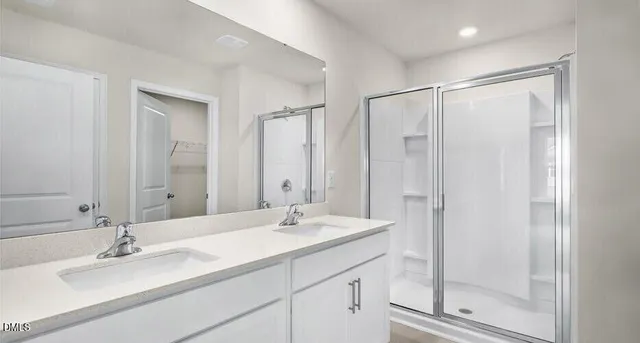 a bathroom with a double vanity sink mirror and shower