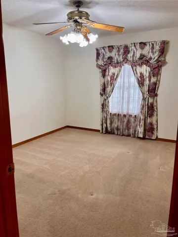 a view of a room with a hanging light and wood floor