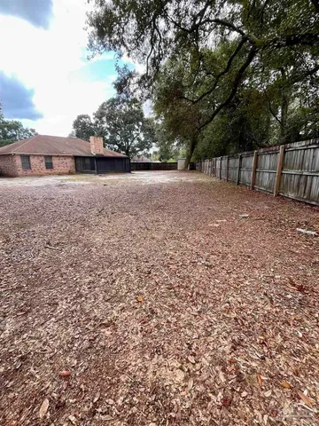 a view of a backyard with large trees