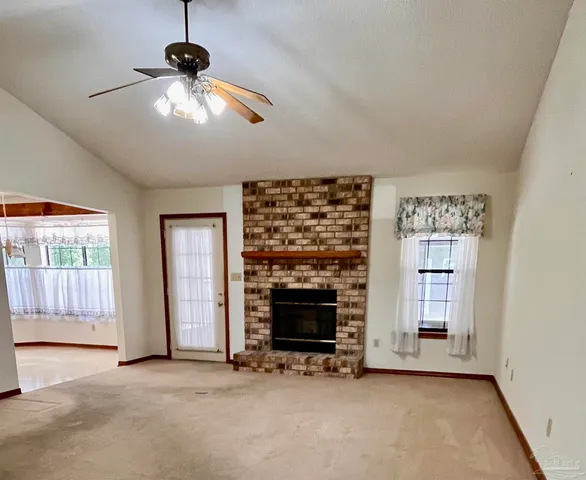 a view of an empty room with window and fireplace