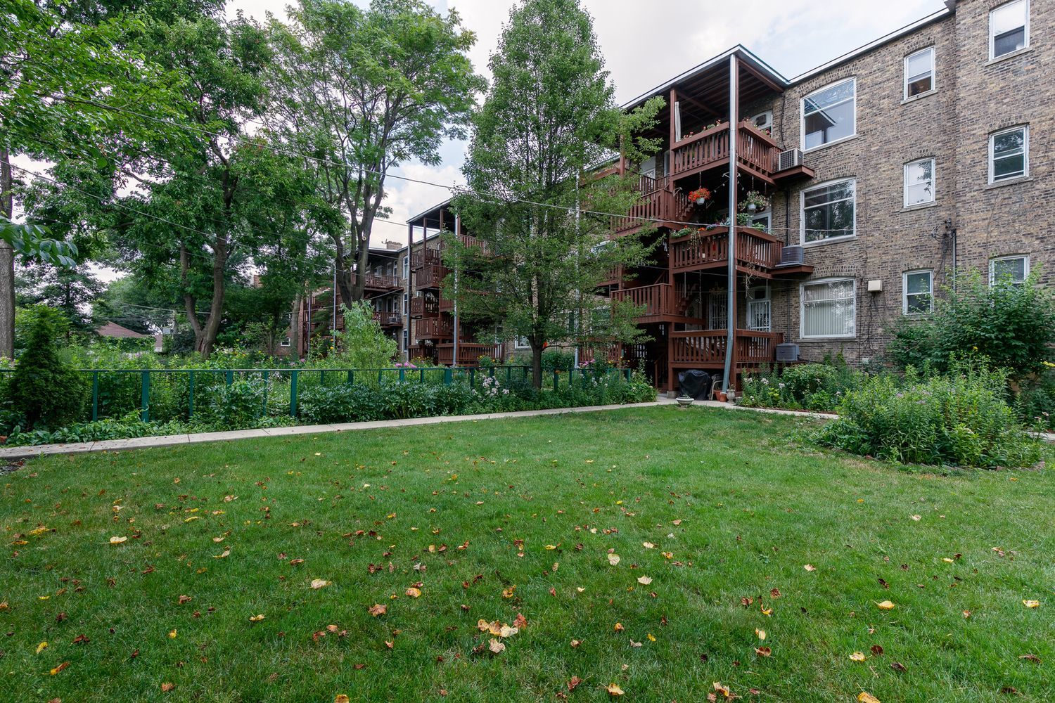 2137 West Cortez Street, Unit 2 Chicago, IL 60622 - Photo 19 of 19 a view of a brick house with a big yard and large trees