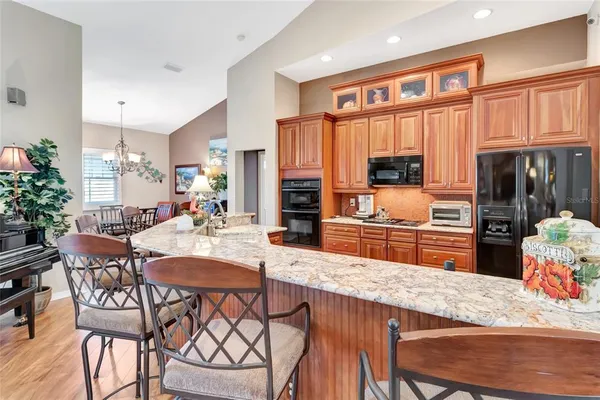 a kitchen with granite countertop a table chairs stove and cabinets