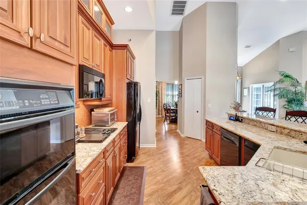 a kitchen with stainless steel appliances granite countertop a stove a sink and a refrigerator