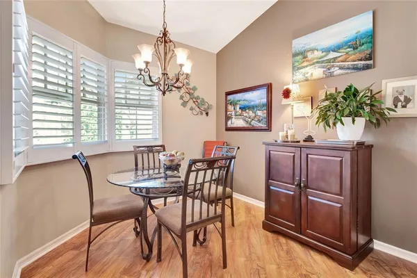 a dining room with furniture potted plants and wooden floor