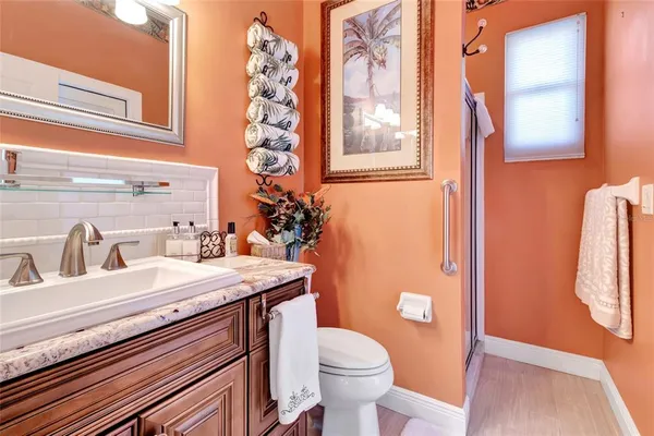 a bathroom with a granite countertop toilet sink and mirror