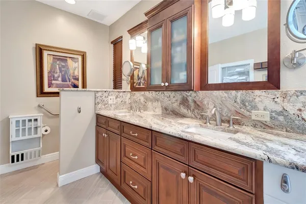 a bathroom with a granite countertop sink and a large mirror