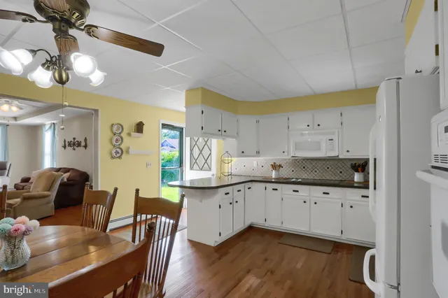a kitchen with granite countertop a sink cabinets and wooden floor