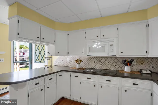 a kitchen with granite countertop white cabinets and white appliances