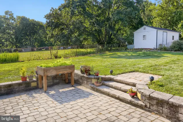 a view of a backyard with lawn chairs and swimming pool
