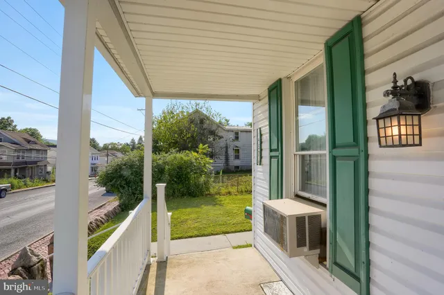 a porch with a table and chairs