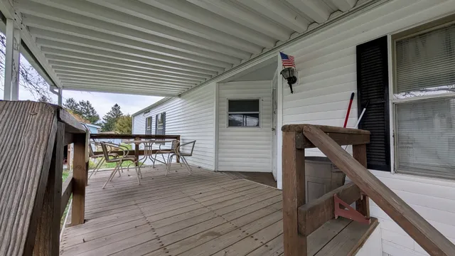 a balcony with chairs a table and chairs with wooden floor