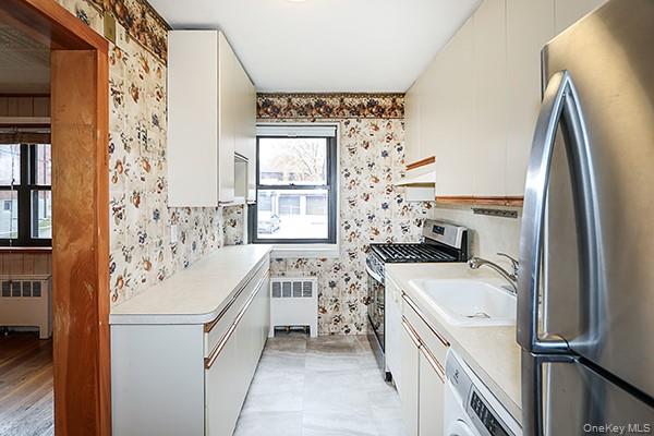 57-54 244th Street, Unit LOWR Queens, NY 11362 - Photo 2 of 6 a bathroom with a sink a washer and dryer