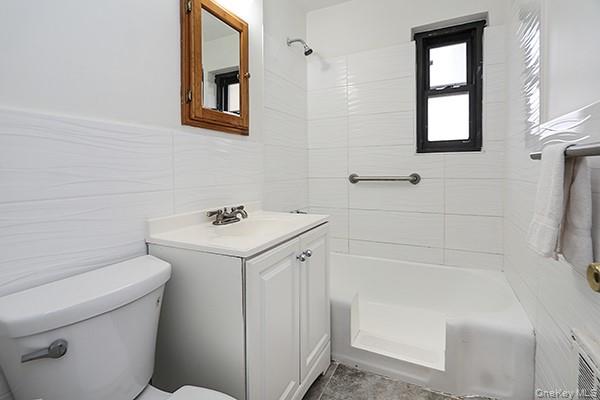 57-54 244th Street, Unit LOWR Queens, NY 11362 - Photo 4 of 6 a bathroom with a sink a toilet and mirror