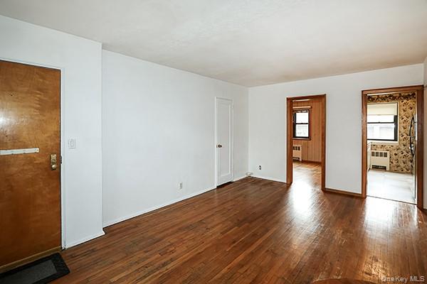 57-54 244th Street, Unit LOWR Queens, NY 11362 - Photo 5 of 6 an empty room with wooden floor and windows